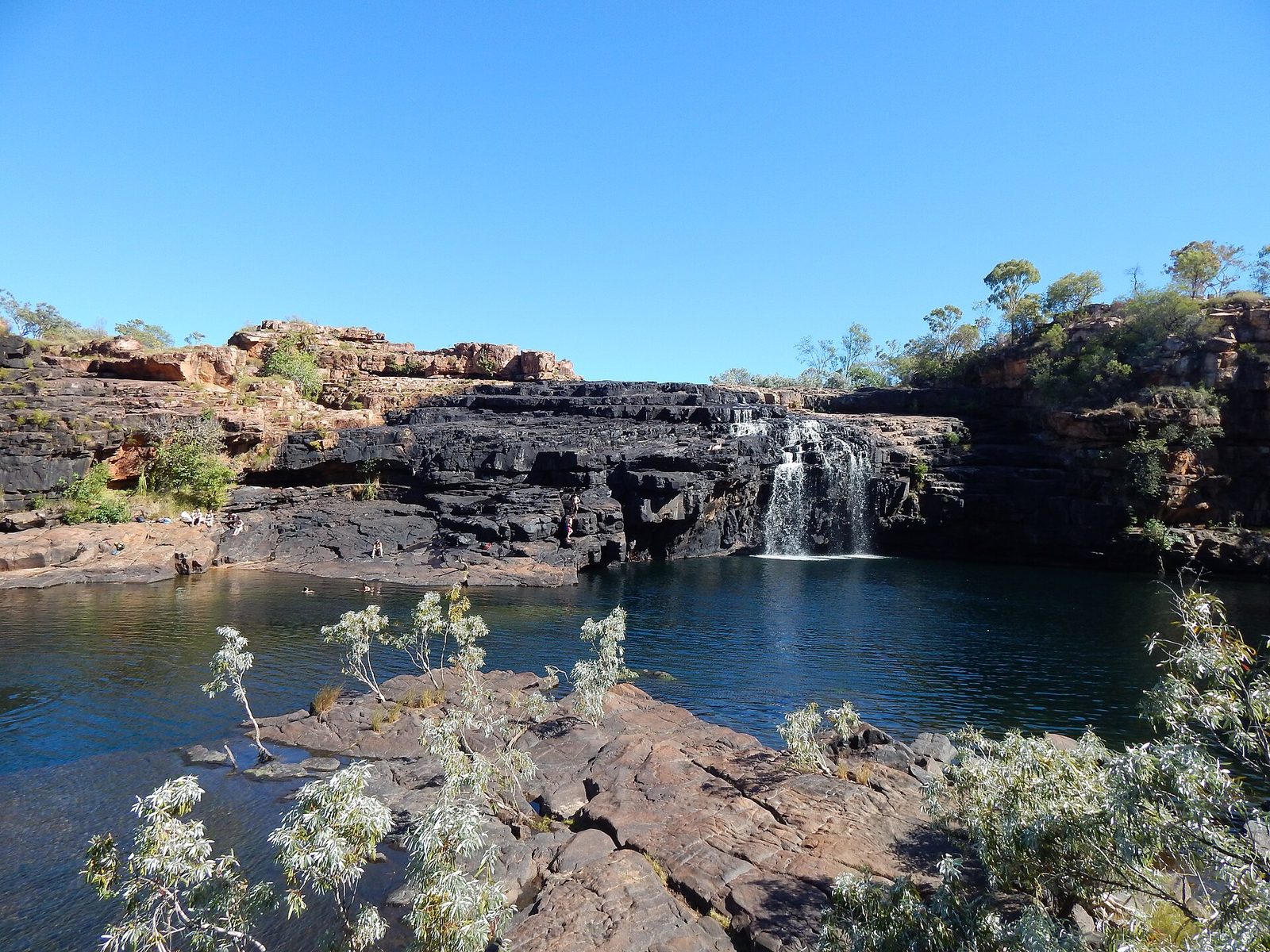 Waterfall dropping over layered rock into the main pool at Manning Gorge
